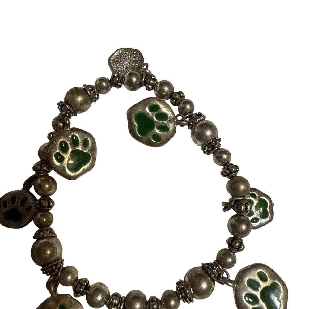 Beaded charm bracelet with green paw print charms.